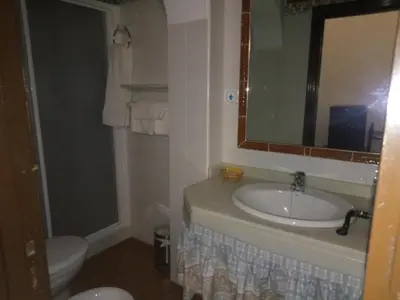 a bathroom with a sink and a toilet and a mirror at Hostal Gran Capitan in Chipiona