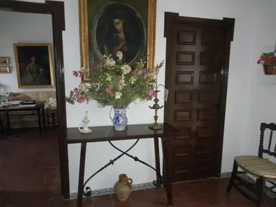 a vase of flowers on a table next to a door at Hostal Gran Capitan in Chipiona