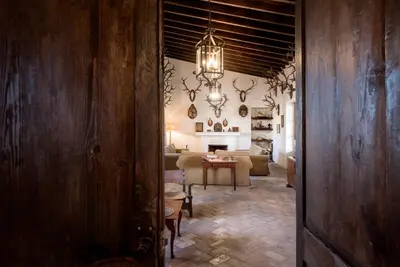 a hallway leading to a living room with a chandelier at HACIENDA LAS MESAS - Luxury Villa Jerez in Jerez de la Frontera