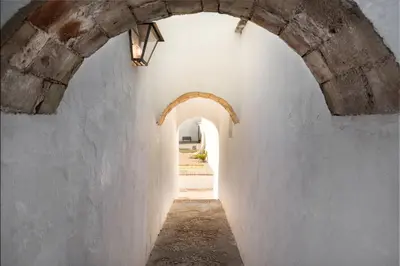 an alley with an archway in a white wall at HACIENDA LAS MESAS - Luxury Villa Jerez in Jerez de la Frontera