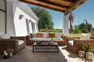 a patio with wicker chairs and a coffee table at HACIENDA LAS MESAS - Luxury Villa Jerez in Jerez de la Frontera
