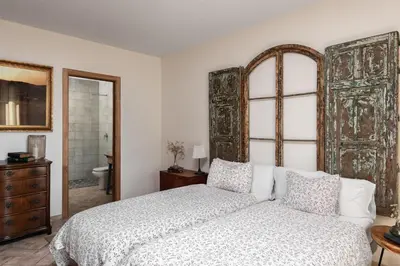 a bedroom with a bed and a large wooden door at HACIENDA LAS MESAS - Luxury Villa Jerez in Jerez de la Frontera
