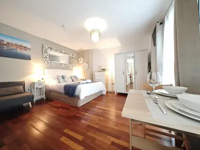 a bedroom with a bed and a table and a dining room at El Estudio del Marqués Little Apartments in Cádiz