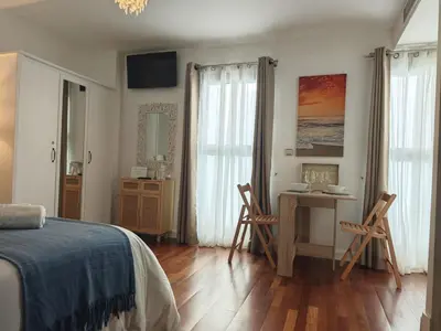 a bedroom with a bed and a table and chairs at El Estudio del Marqués Little Apartments in Cádiz