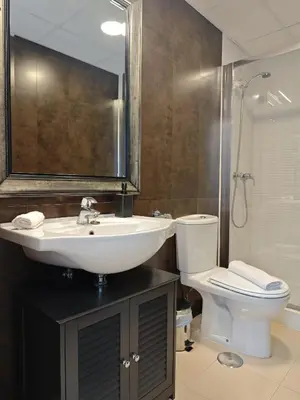 a bathroom with a sink and a toilet and a mirror at El Estudio del Marqués Little Apartments in Cádiz