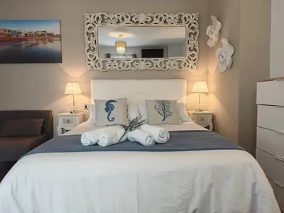 a bedroom with a white bed with towels on it at El Estudio del Marqués Little Apartments in Cádiz