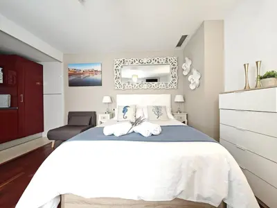 a bedroom with a large bed and a mirror at El Estudio del Marqués Little Apartments in Cádiz