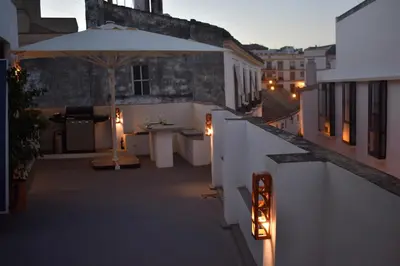 a balcony with an umbrella and a table with lights at Home Apartments Jerez in Jerez de la Frontera