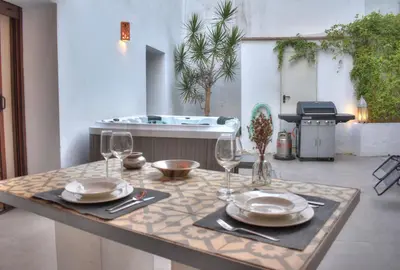 a table with plates and wine glasses and a tub at Home Apartments Jerez in Jerez de la Frontera
