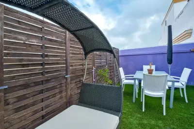 a patio with a fence and a table and chairs at Atico soleado y céntrico in Cádiz