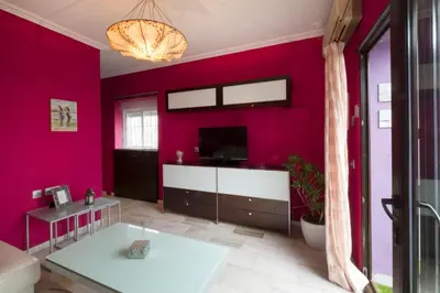 a living room with a red wall at Atico soleado y céntrico in Cádiz