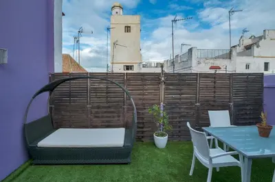 a balcony with a table and chairs and a building at Atico soleado y céntrico in Cádiz