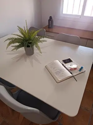 a white table with a book and a plant on it at Atiko La Vista in Arcos de la Frontera