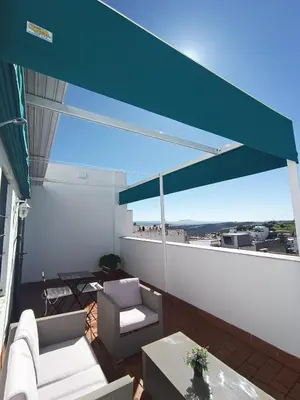 a balcony with a blue canopy and chairs and a table at Atiko La Vista in Arcos de la Frontera