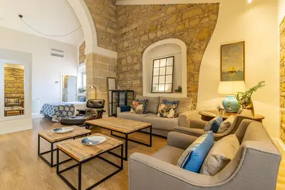 a living room with a stone wall at Sherry Loft Siente Jerez Parking Incluido in Jerez de la Frontera