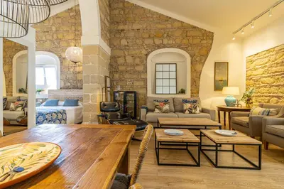 a living room with a stone wall at Sherry Loft Siente Jerez Parking Incluido in Jerez de la Frontera