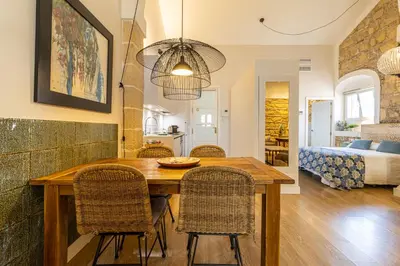 a kitchen and dining room with a wooden table and chairs at Sherry Loft Siente Jerez Parking Incluido in Jerez de la Frontera