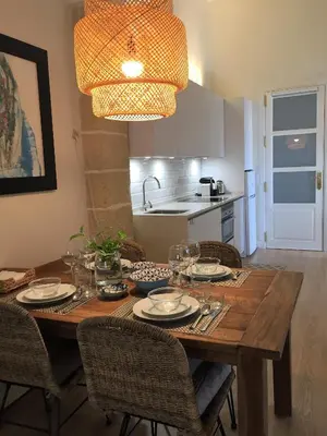 a dining room table with plates and wine glasses at Sherry Loft Siente Jerez Parking Incluido in Jerez de la Frontera