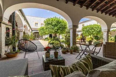 an outdoor patio with chairs and tables and plants at Sherry Loft Siente Jerez Parking Incluido in Jerez de la Frontera