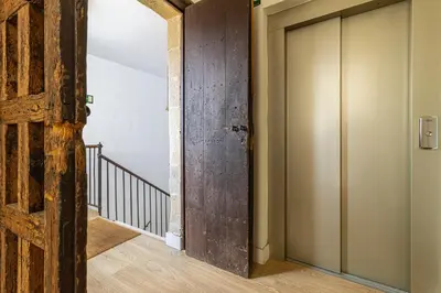 an open wooden door in a hallway with stairs at Sherry Loft Siente Jerez Parking Incluido in Jerez de la Frontera