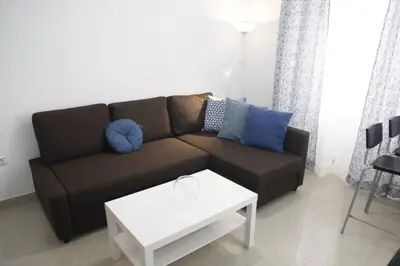 a living room with a brown couch and a white table at Fantástico Piso, Junto a Playa y Pleno Centro in Cádiz
