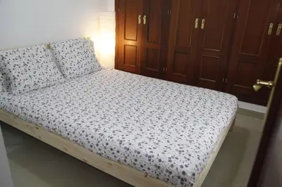 a small bed in a room with wooden cabinets at Fantástico Piso, Junto a Playa y Pleno Centro in Cádiz