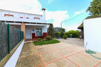 a white house with a fence and a driveway at Los Candiles in Conil de la Frontera