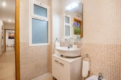 a white bathroom with a sink and a mirror at Gades Suite in Cádiz