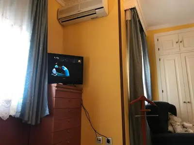 a bedroom with a television and a dresser with a window at Casa Bahía de Cádiz in Puerto Real