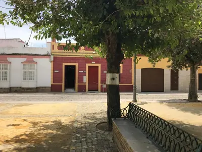 a tree next to a fence in front of a building at Casa Bahía de Cádiz in Puerto Real