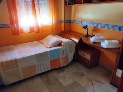 a small bedroom with a bed and a desk at Casa Bahía de Cádiz in Puerto Real