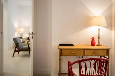 a desk with a chair and a table with a lamp at Apartamento Rosario 49 in Cádiz