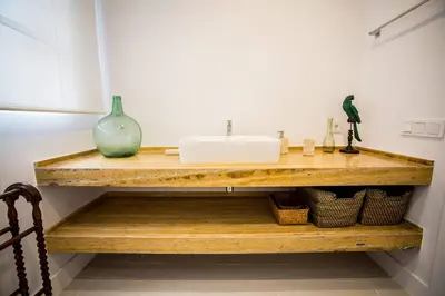 a bathroom with a sink on a wooden shelf at Apartamento Rosario 49 in Cádiz