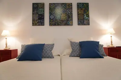 a bedroom with a bed with two blue pillows at Apartamento Rosario 49 in Cádiz
