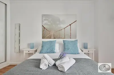 a bedroom with a bed with a bridge painting on the wall at Dulce Arbolí Little Apartments in Cádiz