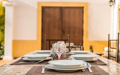 a table with plates and glasses on top of it at Vivienda Rural Olivar de San Telmo in Arcos de la Frontera