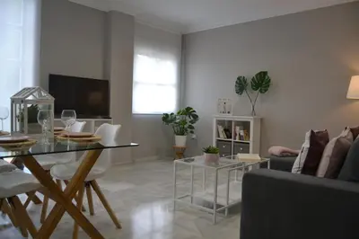 a living room with a table and a couch at Sherryflat Alcázar - Parking in Jerez de la Frontera