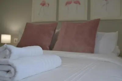 a bed with two rolled towels on top of it at Sherryflat Alcázar - Parking in Jerez de la Frontera