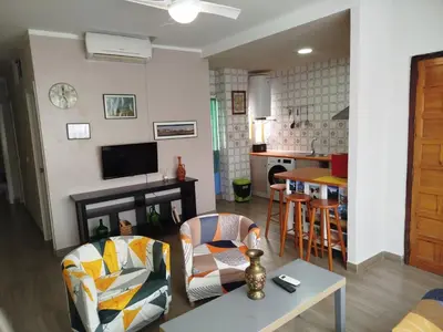 a living room with a table and chairs and a kitchen at Casas Lomas II in Arcos de la Frontera