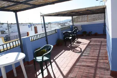 a patio with chairs and tables on a balcony at Casas Lomas II in Arcos de la Frontera