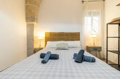 a bedroom with a bed with two pairs of towels on it at Charming Apartment in Jerez de la Frontera