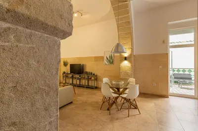 a dining room with a table and white chairs at Charming Apartment in Jerez de la Frontera