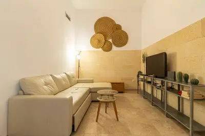 a living room with a white couch and a tv at Charming Apartment in Jerez de la Frontera