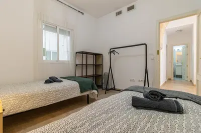 a bedroom with two beds and a mirror at Charming Apartment in Jerez de la Frontera