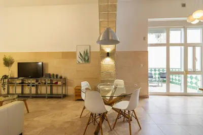 a living room with a table and chairs and a television at Charming Apartment in Jerez de la Frontera
