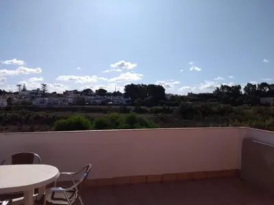 a balcony with a table and a view of a city at Casas Turísticas Bajamar in Sanlúcar de Barrameda