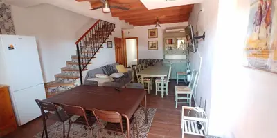 a dining room and living room with a table and chairs at Casas Turísticas Bajamar in Sanlúcar de Barrameda