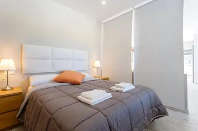 a bedroom with a large bed with two towels on it at Atico FULL Balcony by Cadiz4Rentals in Cádiz