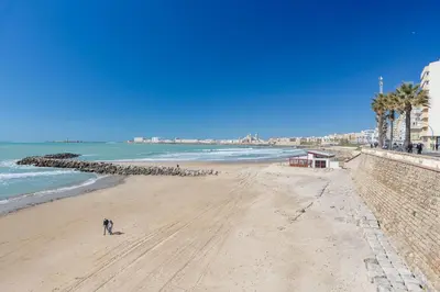 a person standing on a beach next to the ocean at Atico FULL Balcony by Cadiz4Rentals in Cádiz