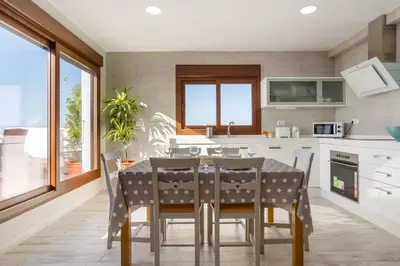 a kitchen with a dining room table with chairs at Atico FULL Balcony by Cadiz4Rentals in Cádiz